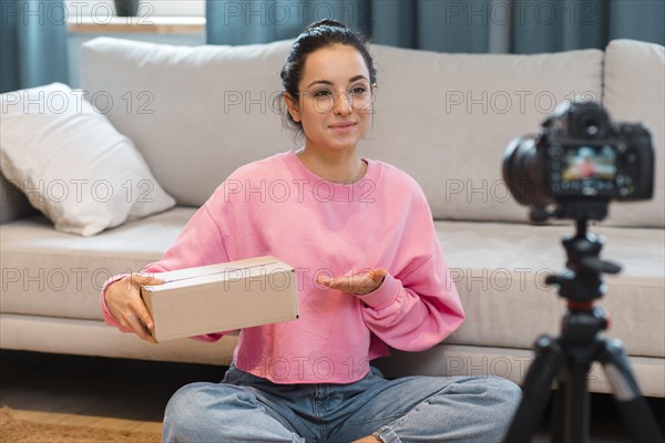 Blogger with box recording herself with camera