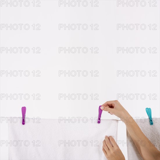 Close up woman taking towels clothesline