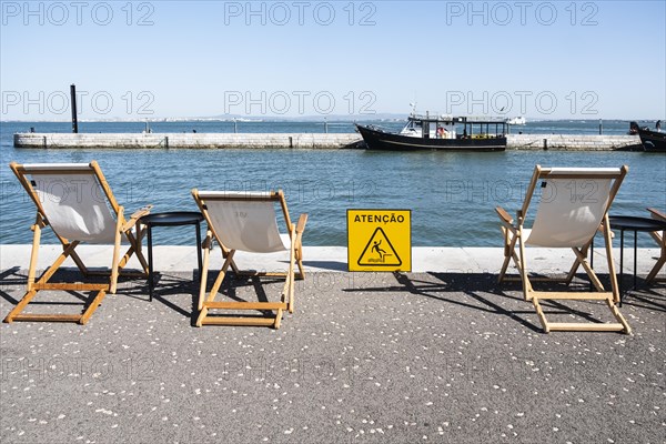 Three deckchairs at a harbour in Lisbon