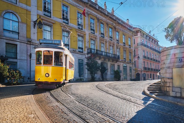 Famous vintage yellow tram 28 in the narrow streets of Alfama district in Lisbon