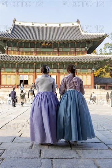 Young woman in traditional hanbok in front of the audience hall Injeongjeon Hall