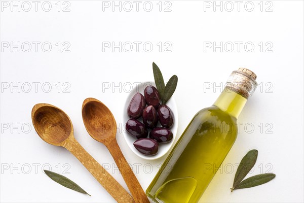 Olive oil bottle purple olives wooden spoons
