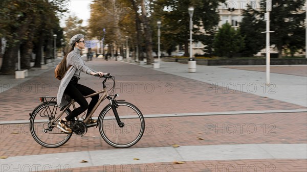 Woman standing bicycle long shot