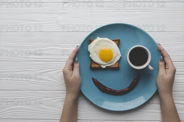 Crop hands holding plate with breakfast
