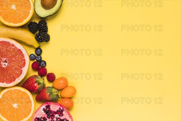 Sliced fruits berries yellow background