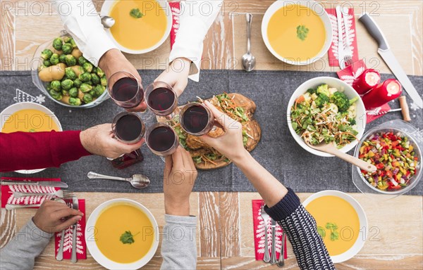 People clanging glasses festive table