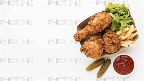 Top view fried chicken drumsticks with ketchup fries with copy space