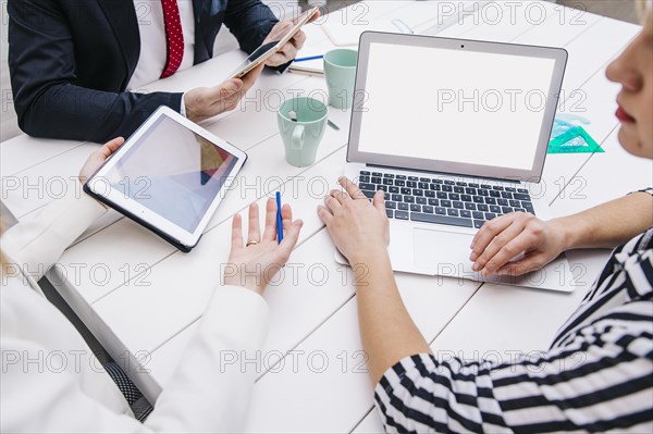 Colleagues with devices working desk