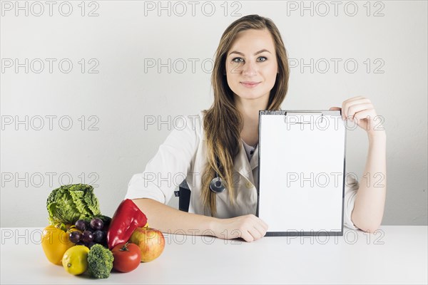 Female dietician holding blank clipboard