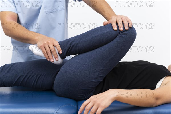 Physiotherapist doing exercises with female patient