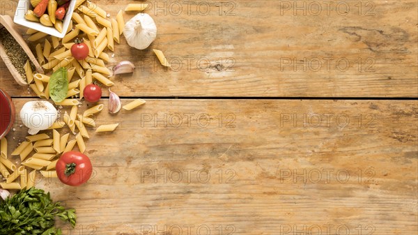 Penne pasta with vegetables ingredients old wooden table