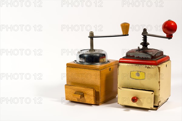 Old wooden colored manual coffee grinders on white background