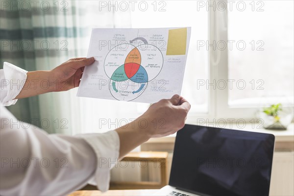 Businessperson s hand holding graph workplace