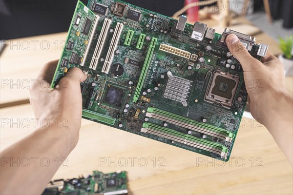 Close up it male technician holding computer mainboard