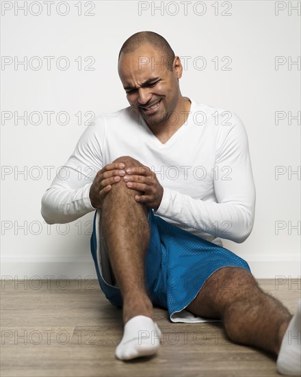 Front view man suffering from knee pain