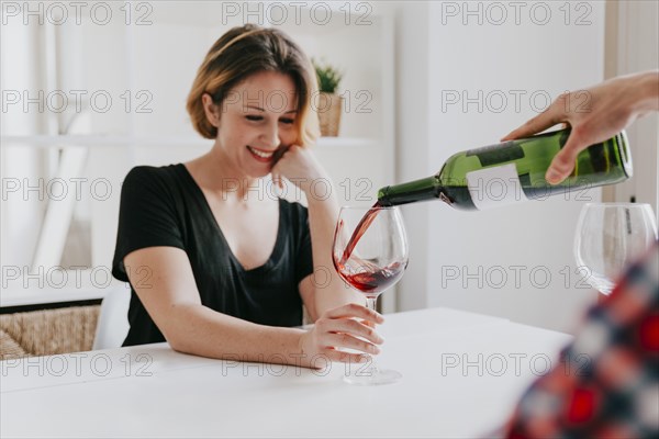 Hand pouring wine girlfriend