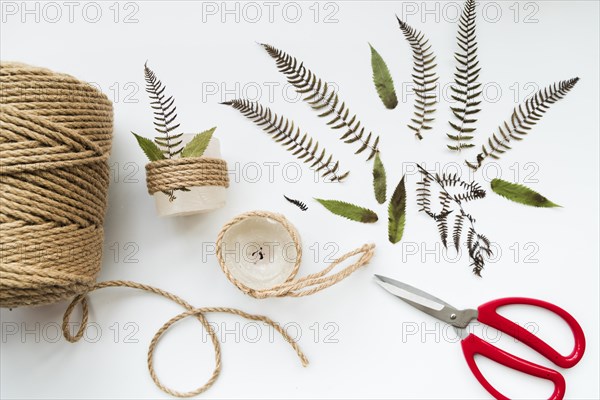Leaves scissor jute string wrapped candles white background