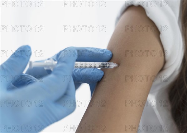 Close up doctor vaccinating little girl