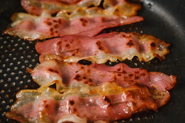 Closeup overhead view of a frying pan with bacon