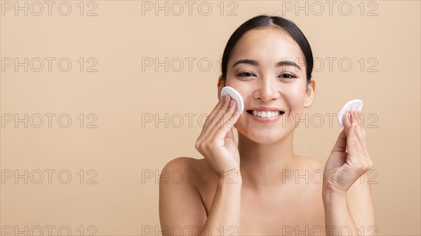Close up smiley woman with cotton pads copy space
