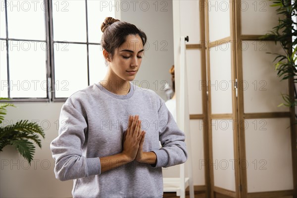 Front view young woman doing yoga home