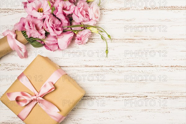 Wrapped pink eustoma flower gift box white old table
