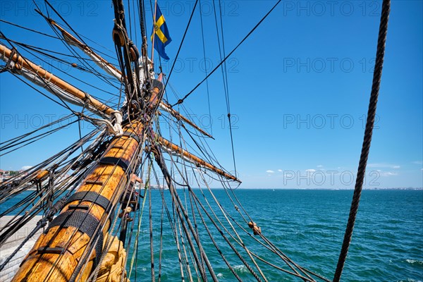 Bowspirit of old wooden sail ship with a lot of gear cordage rope