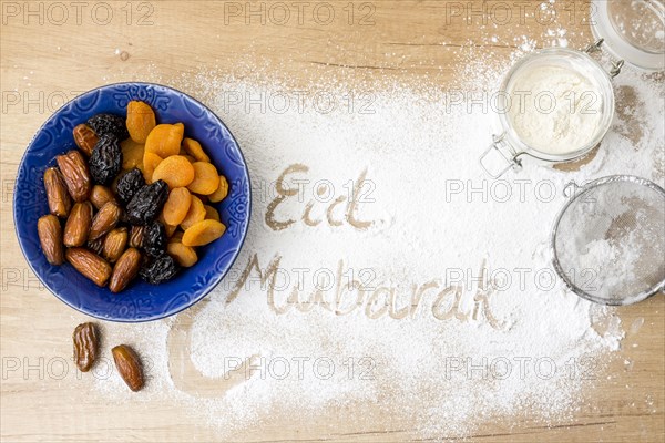 Eid mubarak inscription flour near dried fruits