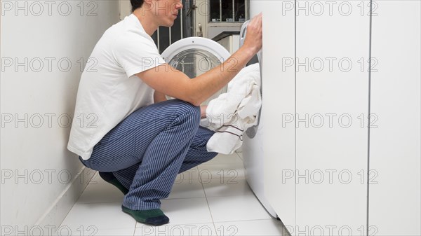 Man putting clothes washing machine