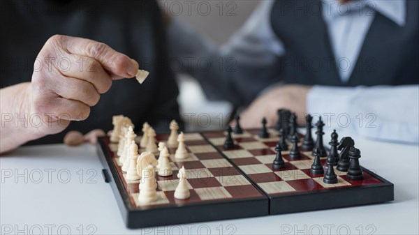Close up elderly playing chess
