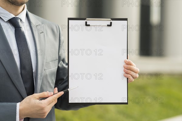 Businessman presenting clipboard