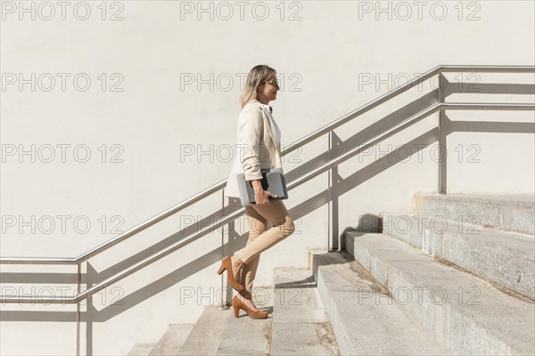 Full shot woman climbing up stairs
