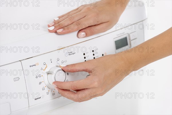 Woman programming washing machine