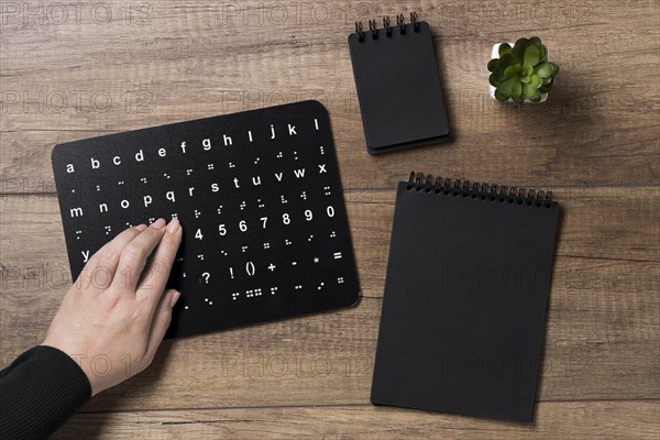 Hand reading braille alphabet board