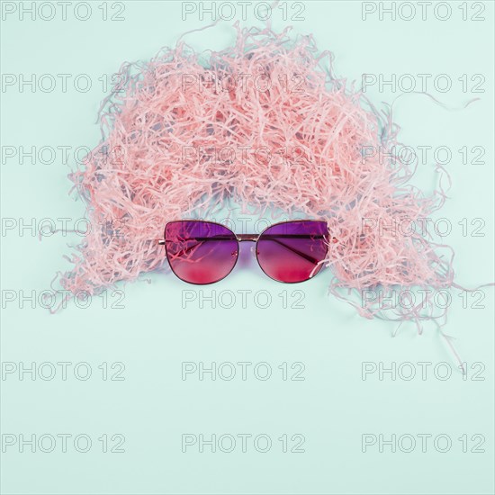 Pink shredded paper wig sunglasses mint background