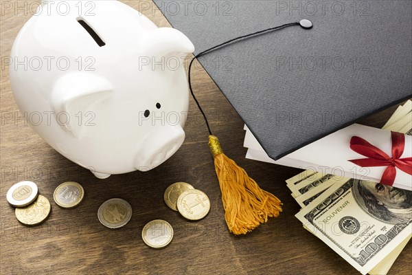 High angle piggy bank with academic cap coins