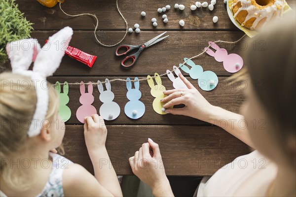 Mother girl decorating garland