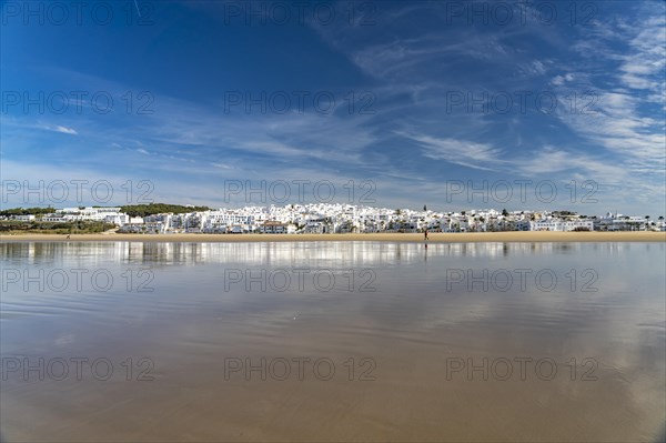 The town view of Conil reflected on the beach Playa De Los Bateles