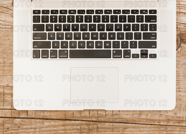 Topview laptop keyboard wooden background