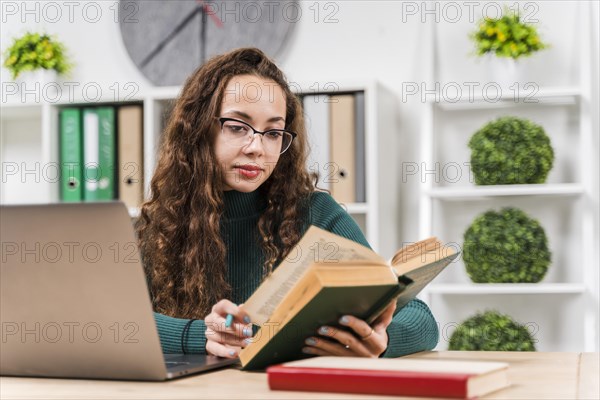 Medium shot girl studying with dictionary