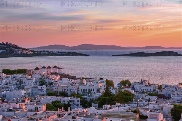 Beautiful sunset view of famous traditional white windmills on top of hill of Chora