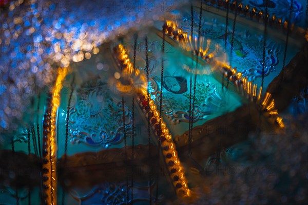 The colourful lights of the Mainfest are reflected in a puddle. The Mainfest on the Mainkai