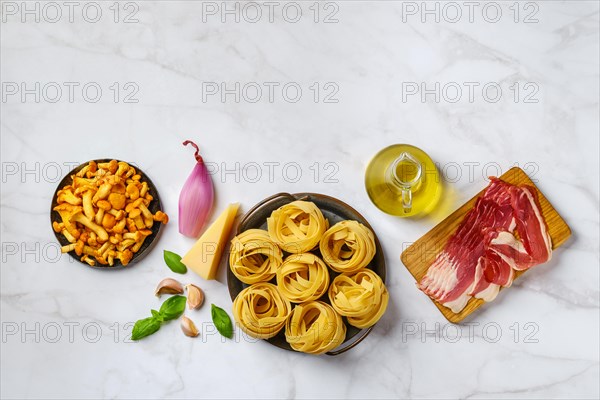 Raw fettuccine and ingredients for mushroom pasta with bacon