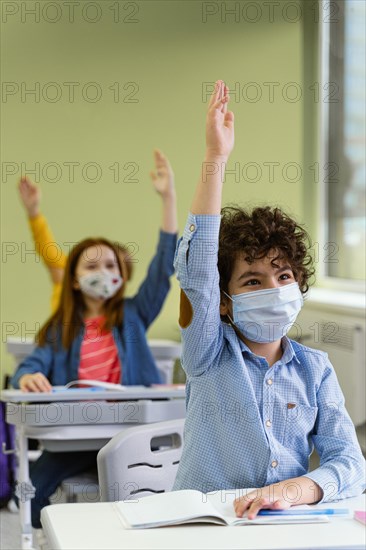 Front view children raising their hands class