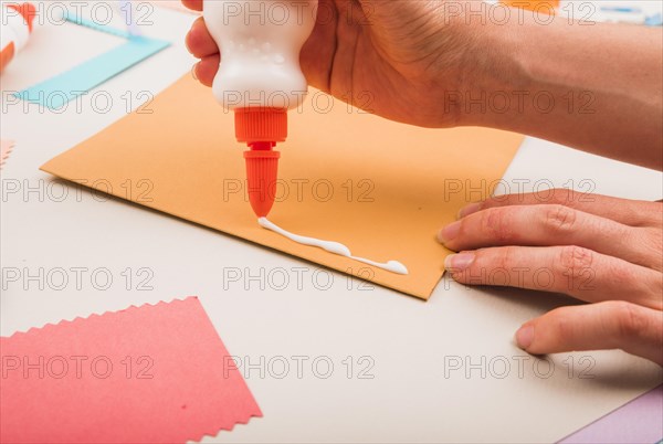 Close up person s hand applying white glue paper