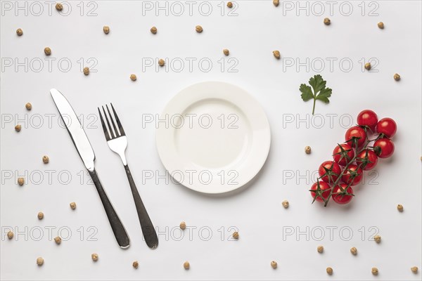 Flat lay fresh tomatoes with plate cutlery