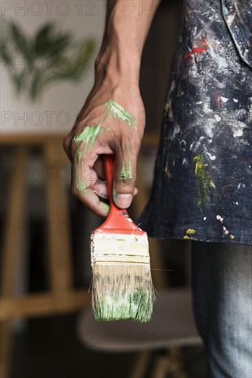 Hand holding stained brush