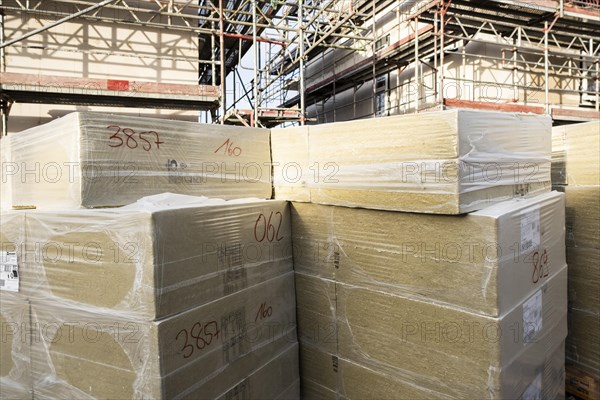 A stack of mineral wool insulation boards on a construction site