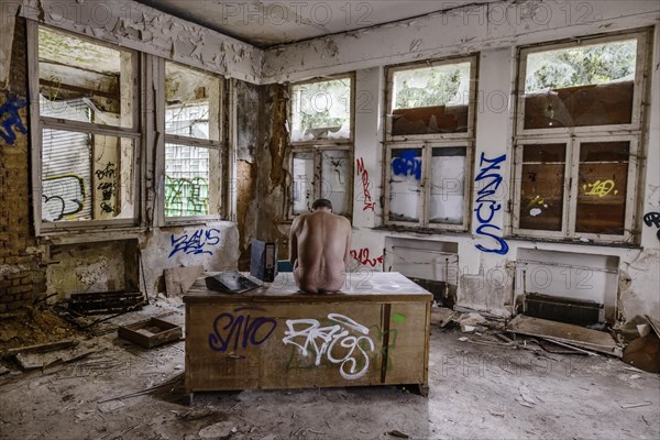 Man dressed in suit wearing VR glasses in a dilapidated office building