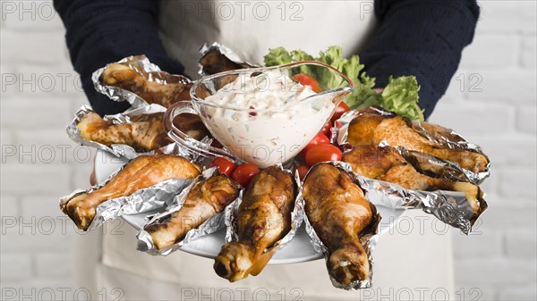 Chef holding plate with chicken